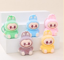 Load image into Gallery viewer, Five colorful fuzzy Keychains with bunny ears on a light background with steps
