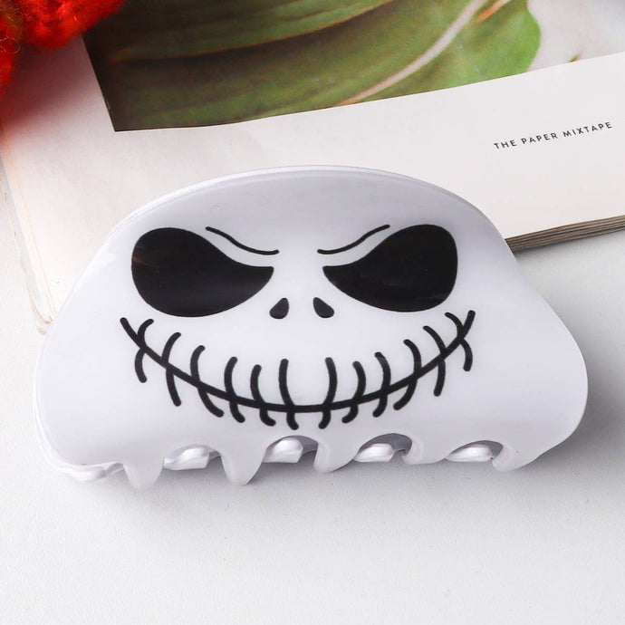 White hair clip with black skull design on a white background